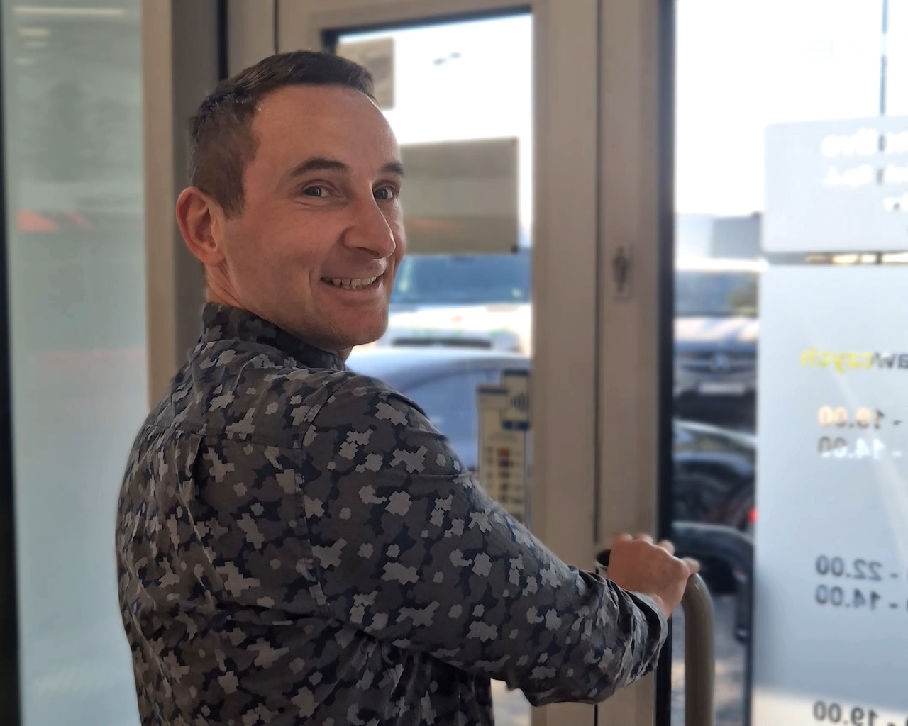 Na zdjęciu widzisz uśmiechniętego mężczyznę opuszczającego serwis Mercedes-Benz