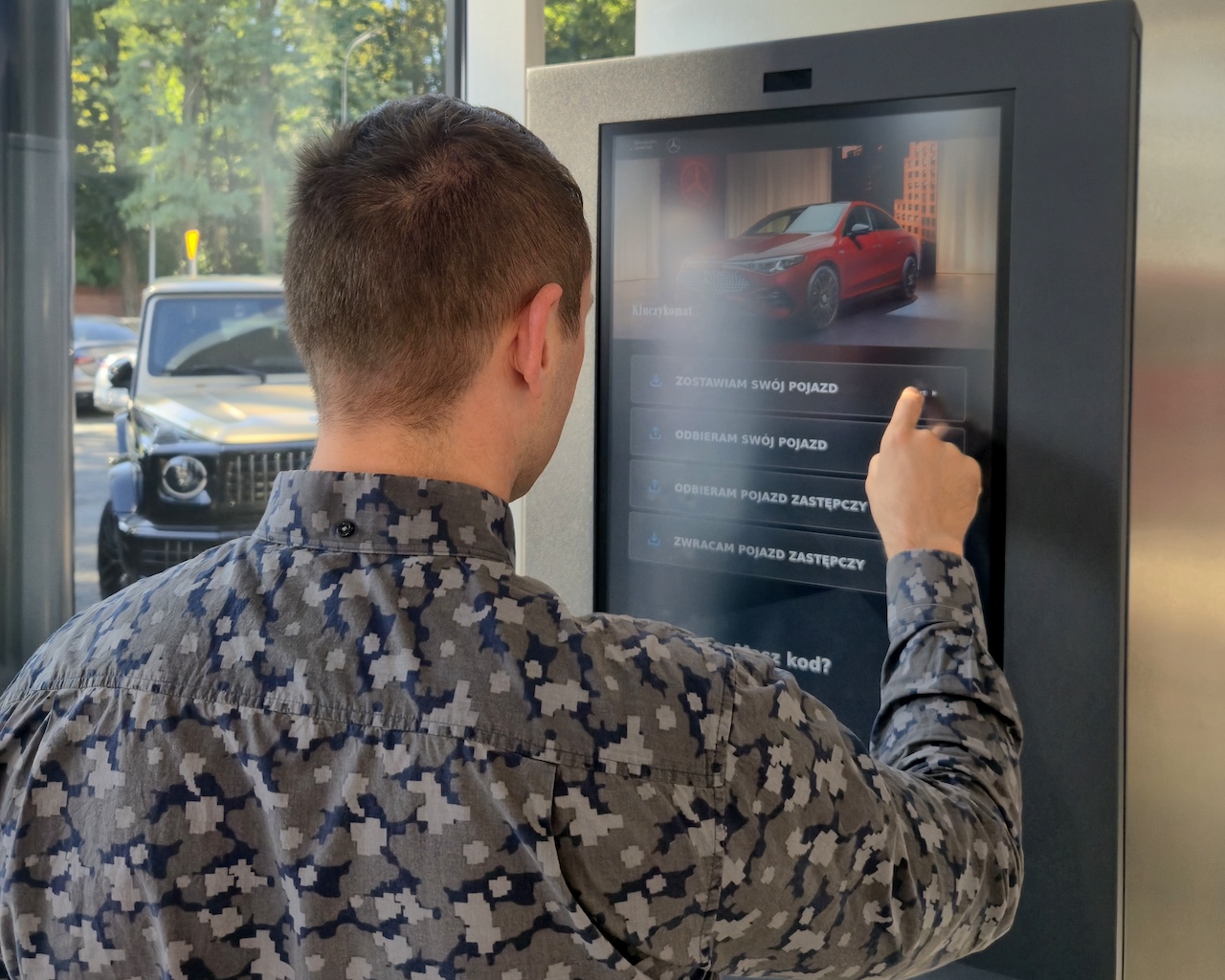 Na zdjęciu widzisz mężczyznę korzystającego z kluczykomatu.