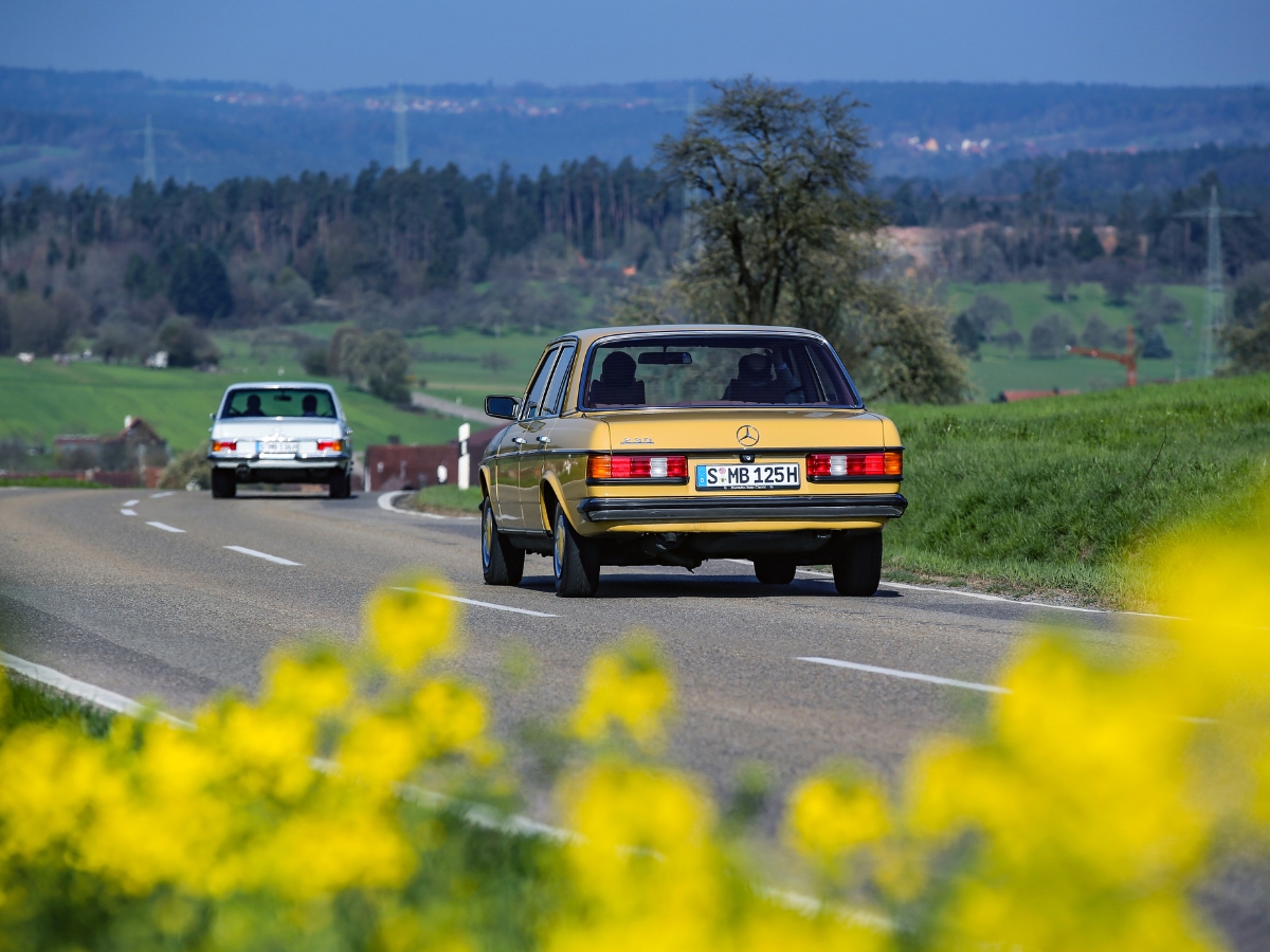 zdjęcie przedstawia klasyczny model Mercedes-Benz, który jedzie po drodze